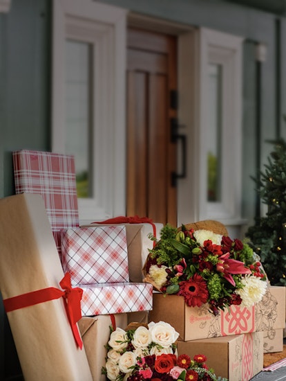 Festively wrapped gifts with a vibrant floral arrangement, perfect for holiday celebrations.