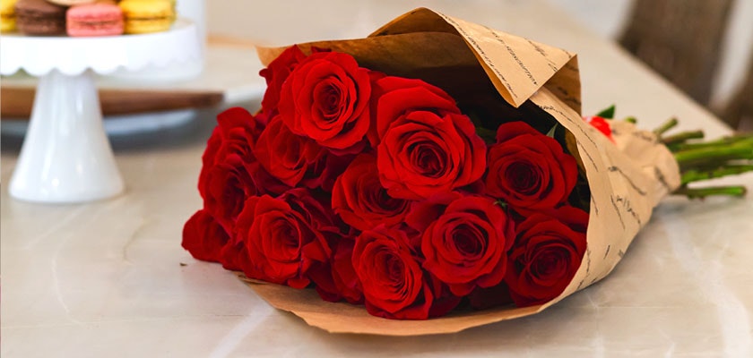A beautiful bouquet of vibrant red roses wrapped in elegant paper, perfect for gifts.