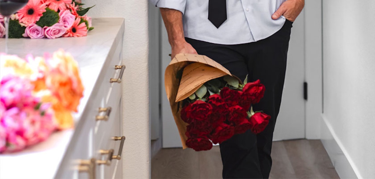 Elegant bouquet of red roses held by a person, adding romance to any setting.