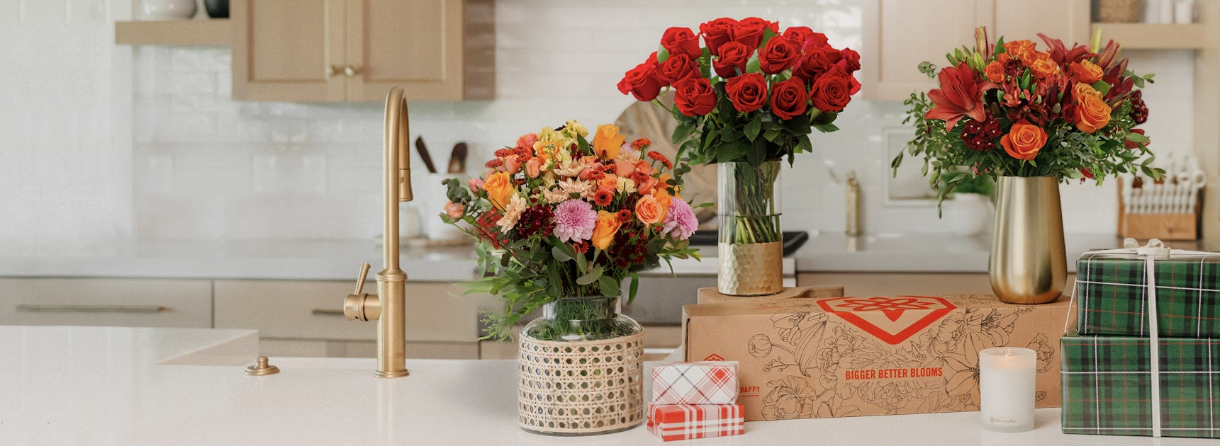 Vibrant floral arrangements with red roses and assorted blooms in a modern kitchen setting.