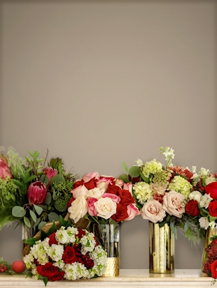 Elegant floral arrangement featuring red and blush roses in stylish vases, perfect for gifts.