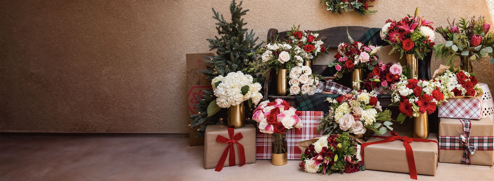 An elegant display of festive floral arrangements and beautifully wrapped gifts.
