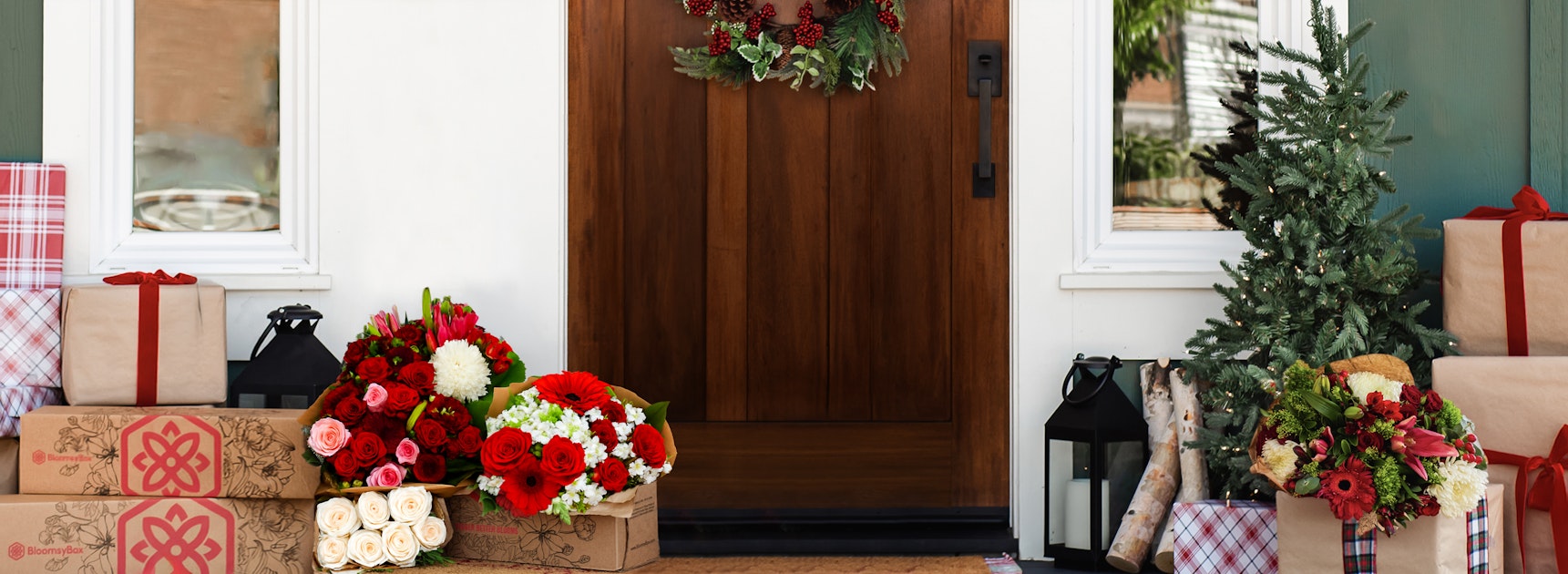 Festive front porch decorated with vibrant floral arrangements and Christmas gifts.