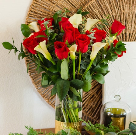 Elegant bouquet of red roses and white calla lilies in a chic vase, perfect for decor.