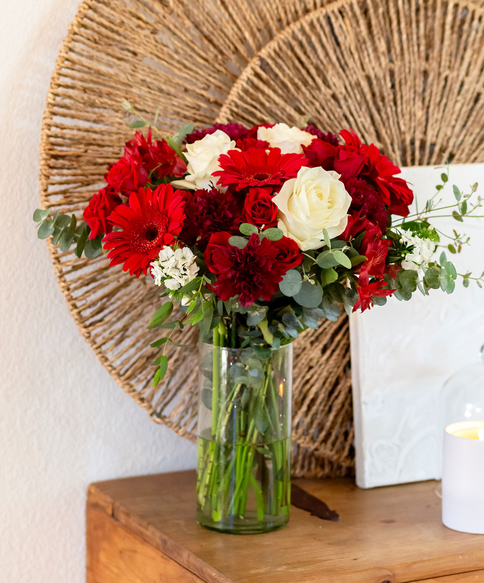 Vibrant red and white floral bouquet in a clear vase, perfectly styled for home decor.