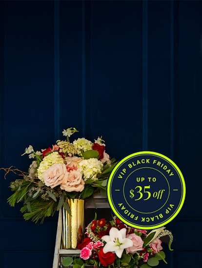 Beautiful floral arrangement featuring roses, hydrangeas, and seasonal blooms, adorned with a Black Friday sale sign.