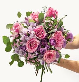 Vibrant bouquet featuring pink roses, purple alstroemeria, and lush greenery.