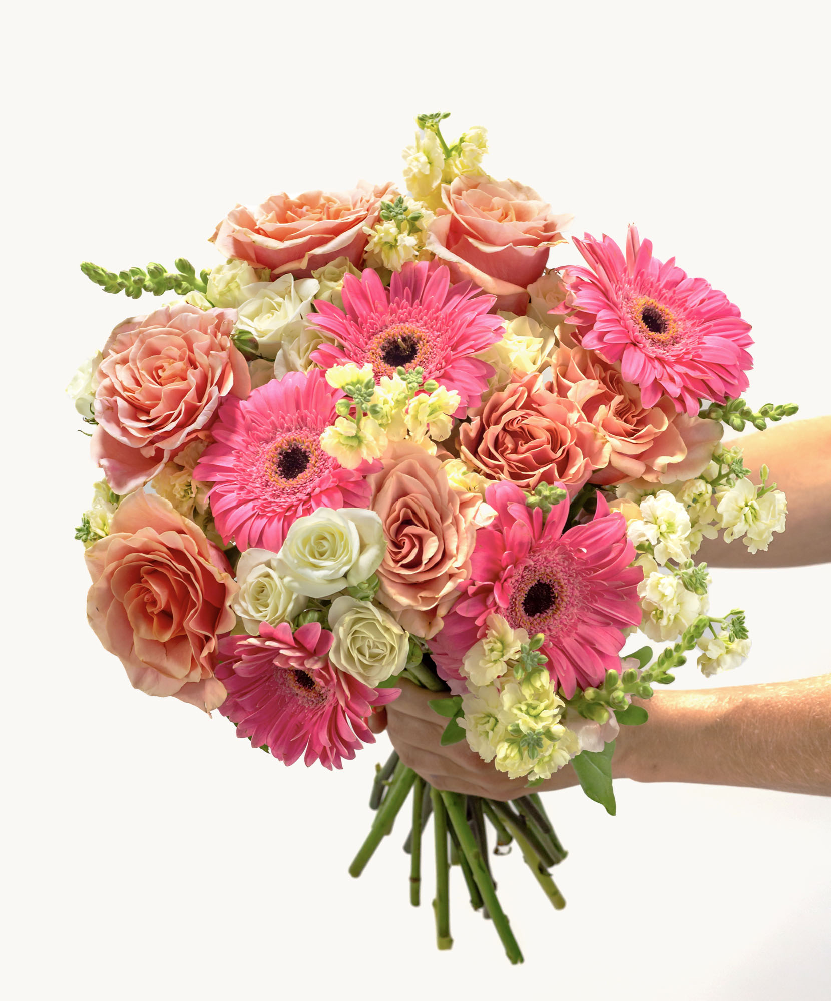 Blooming floral bouquet featuring pink gerbera daisies, roses, and delicate white blooms.