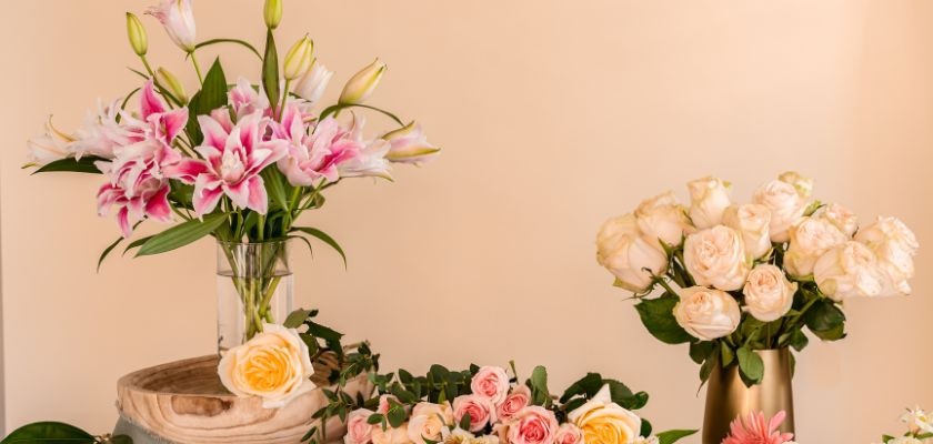 Elegant floral display featuring pink lilies and soft pastel roses in stylish vases.
