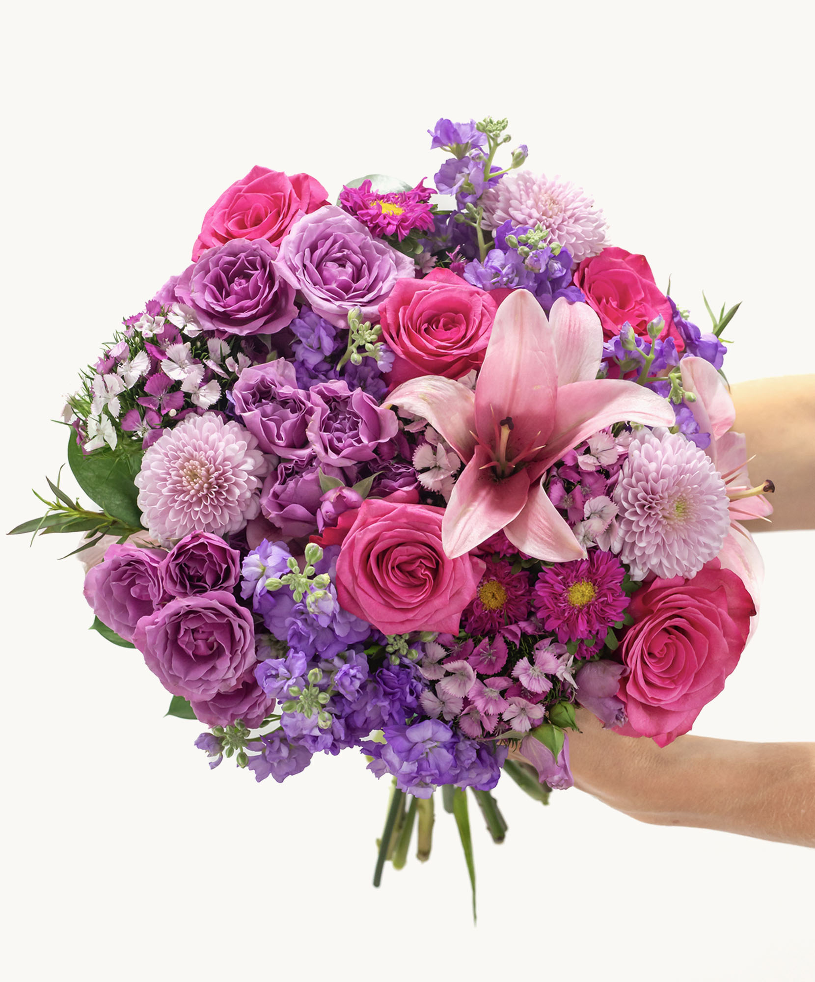 Vibrant bouquet featuring pink roses, purple lilies, and assorted blooms in a lush arrangement.