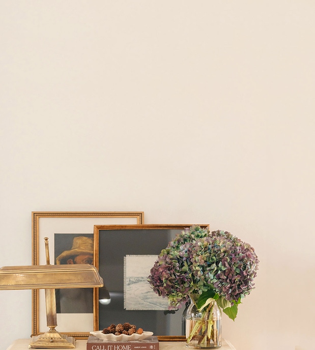 An elegant display featuring a hydrangea bouquet and framed art on a stylish table.