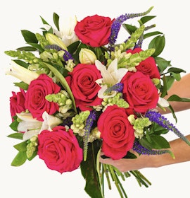 Vibrant bouquet featuring pink roses, white lilies, and green accents, perfect for gifting.