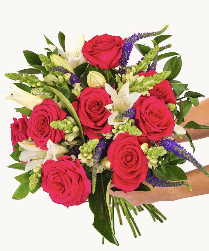 Vibrant bouquet featuring pink roses, white lilies, and green accents, perfect for gifting.