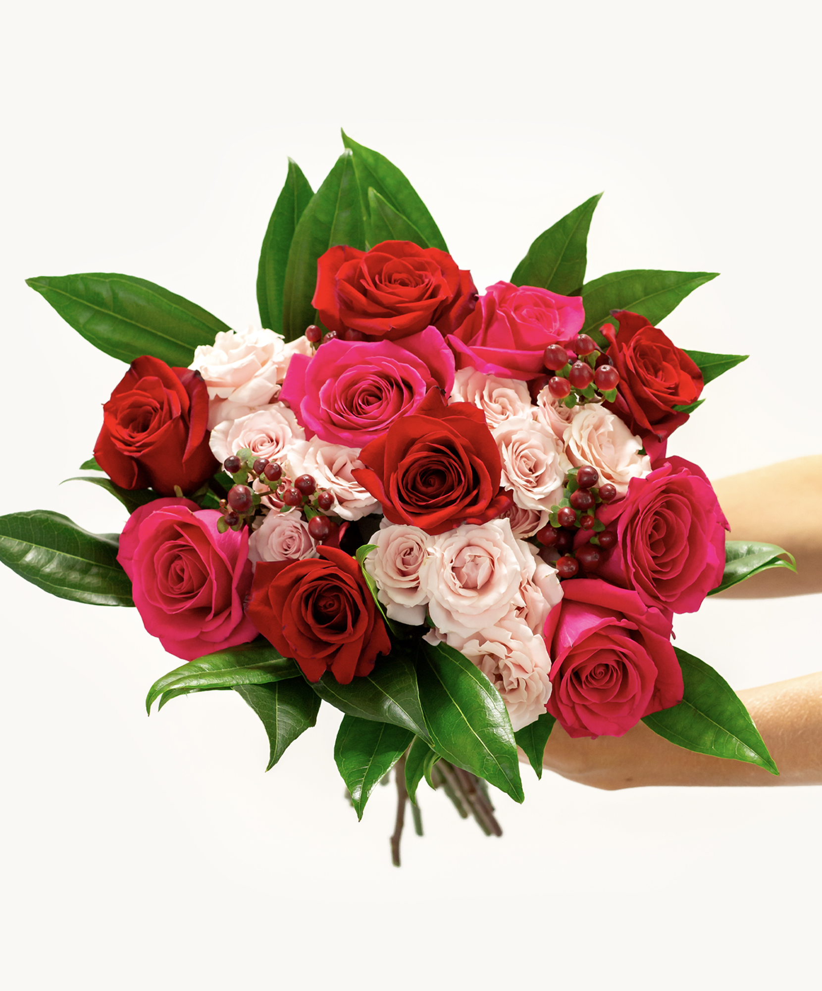 Vibrant rose bouquet featuring deep red, soft pink, and bold magenta blooms with lush greenery.