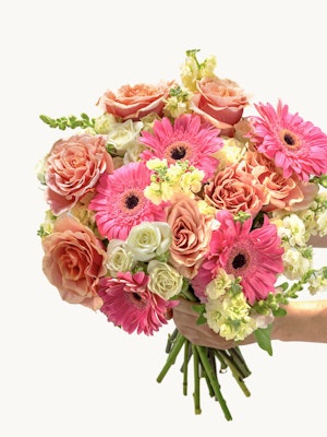 Vibrant floral bouquet featuring pink gerbera daisies, roses, and mixed blooms, perfect for celebrations.
