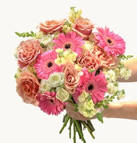 Vibrant floral bouquet featuring pink gerbera daisies, roses, and mixed blooms, perfect for celebrations.
