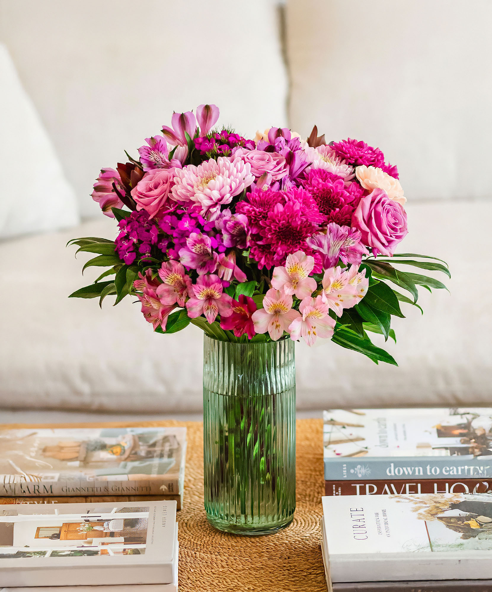 Vibrant floral arrangement featuring pink roses, chrysanthemums, and alstroemeria in a stylish vase.