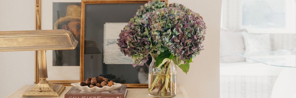 A vibrant arrangement of hydrangeas in a glass vase, complementing a cozy interior decor.