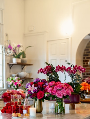 Vibrant floral display featuring roses and orchids in a stylish shop setting.