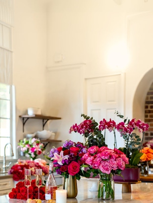 Vibrant floral arrangement featuring pink roses and orchids in a chic setting.