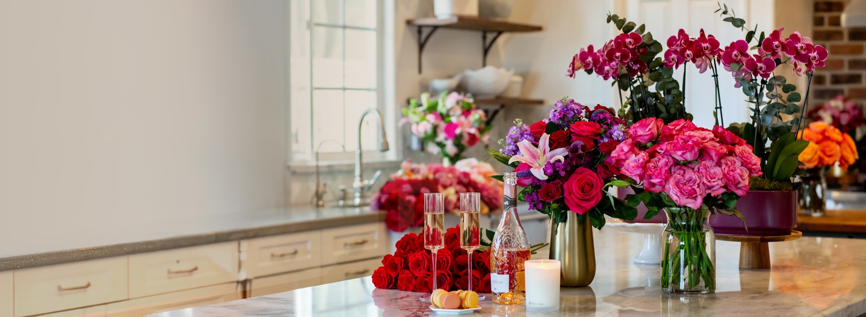 Vibrant flower arrangements in an elegant kitchen setting, showcasing roses and orchids.