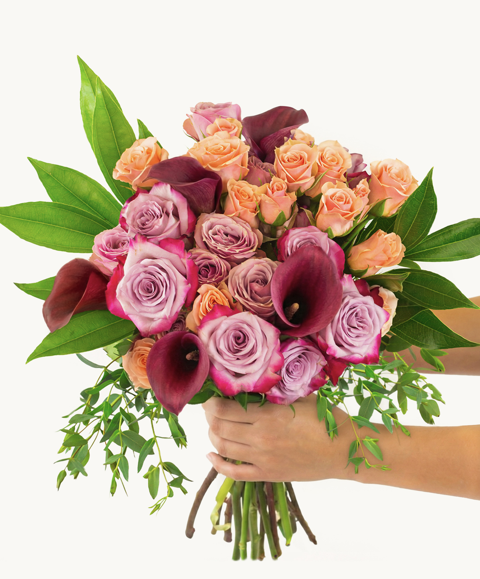 Vibrant bouquet featuring pink and peach roses with elegant calla lilies and lush greenery.
