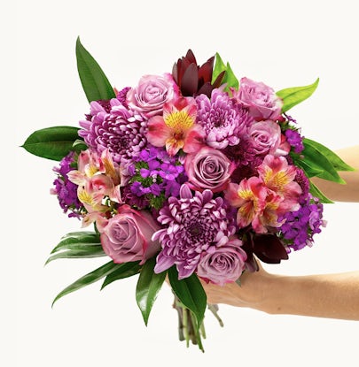 Vibrant bouquet featuring pink roses, chrysanthemums, and lush greenery, ideal for celebrations.