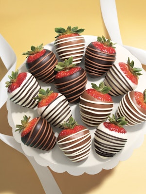 Decadent chocolate-covered strawberries elegantly arranged on a white platter, perfect for celebrations.