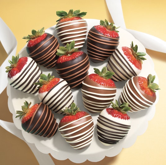 Decadent chocolate-covered strawberries elegantly arranged on a white platter, perfect for celebrations.