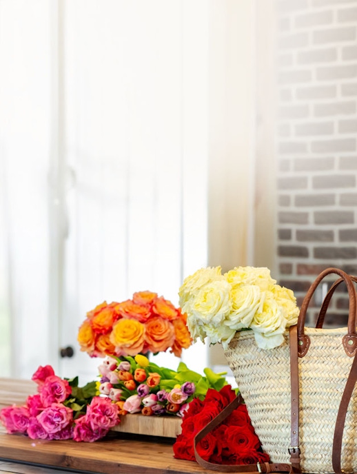 Vibrant flower arrangement featuring roses, tulips, and peonies in a stylish basket.