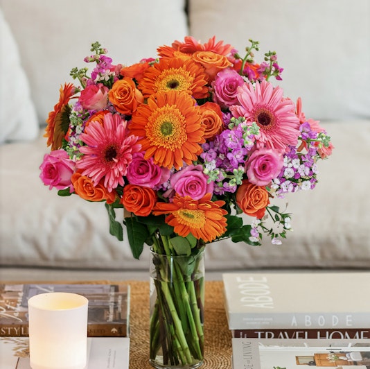 Vibrant floral bouquet with orange gerbera daisies and pink roses, perfect for any occasion.
