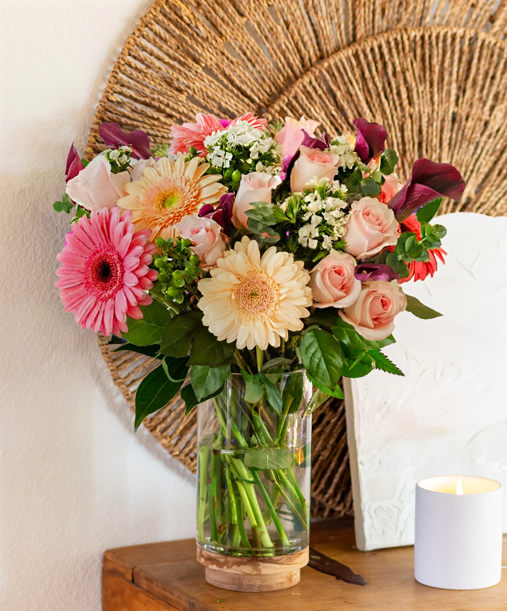 Vibrant floral arrangement featuring pink gerbera daisies and delicate roses in a vase.