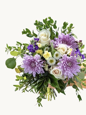 Vibrant bouquet featuring lavender chrysanthemums, roses, and lush greenery.
