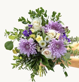 Vibrant bouquet featuring lavender chrysanthemums, roses, and lush greenery.