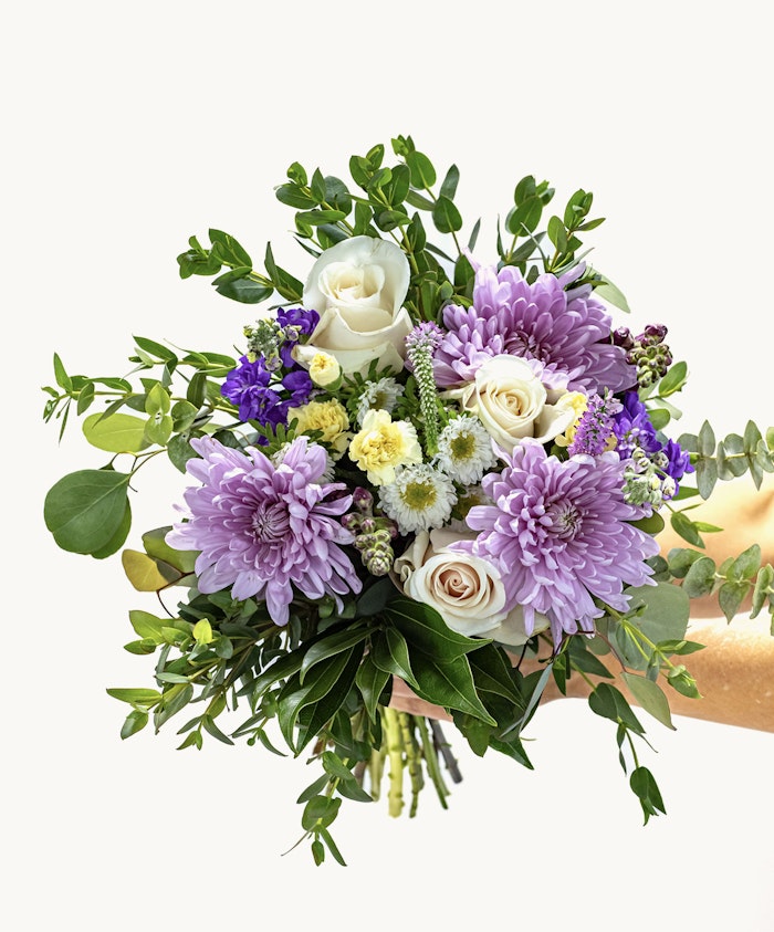 Vibrant bouquet featuring lavender chrysanthemums, roses, and lush greenery.