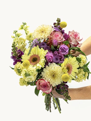 Vibrant bouquet featuring yellow, purple, and pink flowers, perfect for celebrations.