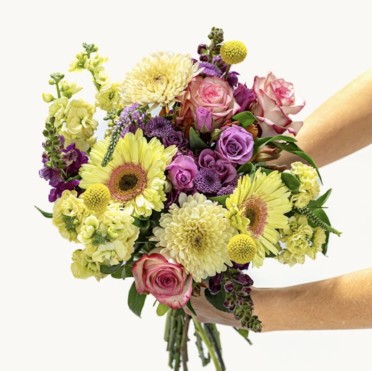 Vibrant bouquet featuring yellow, purple, and pink flowers, perfect for celebrations.