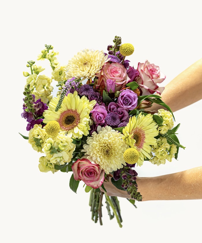 Vibrant bouquet featuring yellow, purple, and pink flowers, perfect for celebrations.