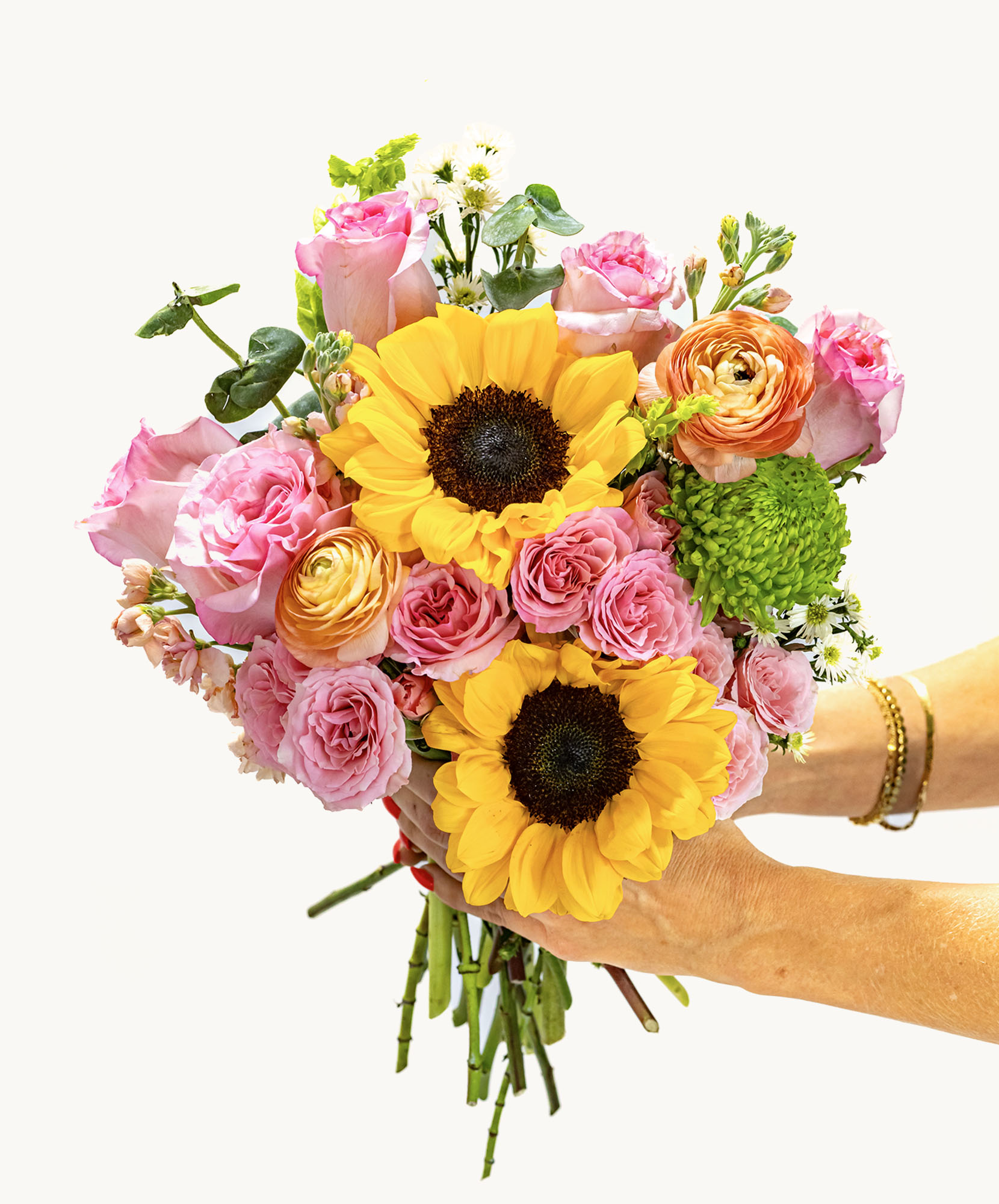 Vibrant bouquet featuring sunflowers, pink roses, and lush greenery, ideal for celebrations.