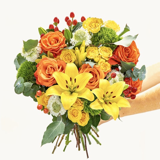 Vibrant bouquet featuring orange roses, yellow lilies, and lush greenery for special occasions.