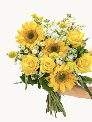 Bright and cheerful bouquet featuring sunflowers, yellow roses, and white accents.
