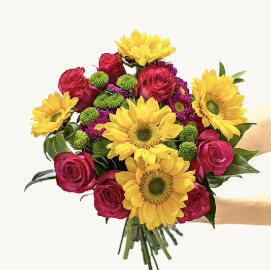 Vibrant bouquet featuring sunflowers, pink roses, and green chrysanthemums, ideal for celebrations.