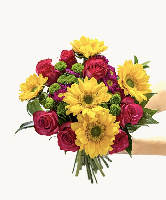 Vibrant bouquet featuring sunflowers, pink roses, and green chrysanthemums, ideal for celebrations.
