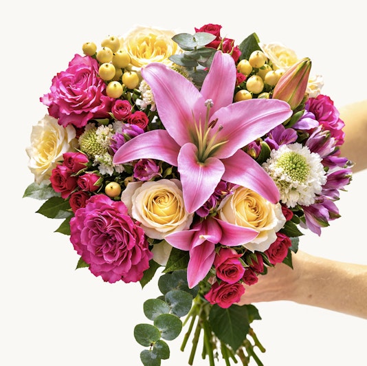 Vibrant flower bouquet featuring pink lilies, yellow roses, and colorful blooms.