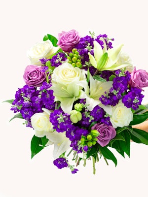 Vibrant floral bouquet featuring white lilies, purple and lavender roses, and lush greenery.