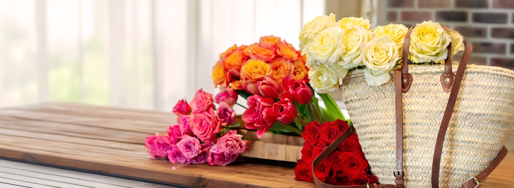 Colorful spring bouquet featuring vibrant roses and tulips in a stylish wicker basket.
