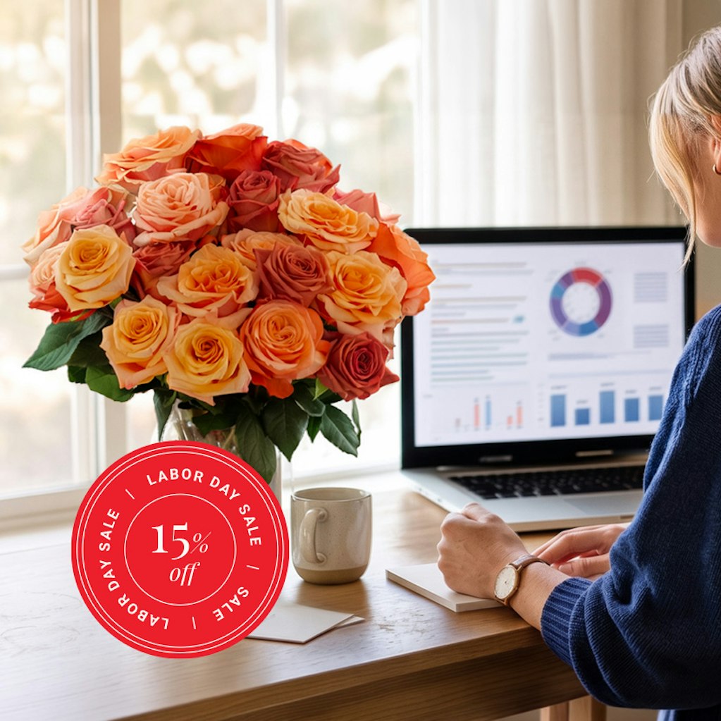 A vibrant bouquet of orange and pink roses brightening a workspace, perfect for Labor Day.