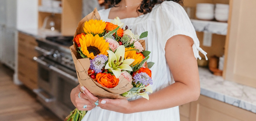 Bright and cheerful floral bouquet filled with sunflowers, lilies, and roses.