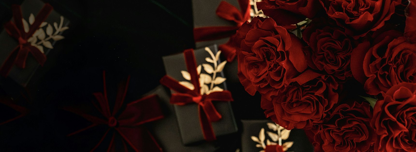 Luxurious red roses paired with elegant gift boxes adorned with ribbons, perfect for gifting.