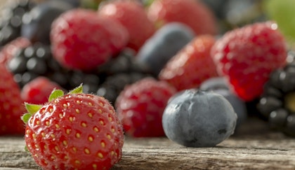 An assortment of strawberries, blueberries, raspberries and blackberries on a wooden table